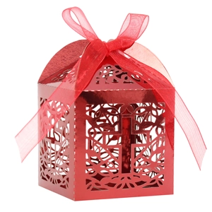 Detail of red laser-cut wedding favor box with cross pattern and silk ribbon