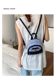 Détail du mini sac à dos bleu avec imprimés cœurs, nœud en satin et bordure à volants