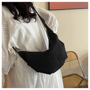 Detailed close-up of a black crescent crossbody bag made from durable nylon material