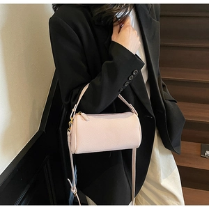 Detailed macro view of light pink lychee grain leather texture and gold hardware zipper