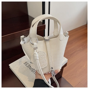 Close-up of white crocodile pattern mini bucket bag with animal charm and silver hardware