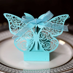 Detail of laser-cut rose patterns on light blue wedding candy box with silk ribbon