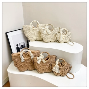 Détails de sacs à main en paille de deux couleurs et trois tailles avec nœuds en dentelle