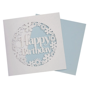 Detailed laser-cut Happy Birthday card featuring white floral cutout over light blue background
