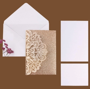 Detail of laser-cut glitter gold invitation set with lace pattern and white insert cards