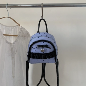 Détail d'un mini sac à dos rayé bleu clair avec cœurs noirs et décoration nœud