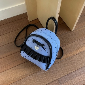 Détail du mini sac à dos à rayures bleues avec volants noirs et nœud décoratif