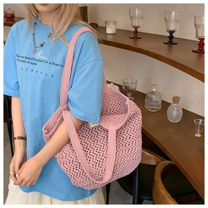 Gros plan d'un sac cabas rose crocheté à la main avec maille évidée et large bandoulière