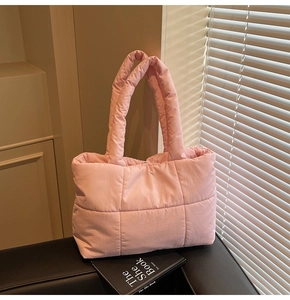 Vue détaillée du sac cabas matelassé rose avec de grands carreaux et des anses rembourrées