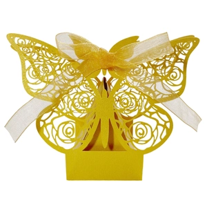 Macro view of laser-cut rose patterns and organza ribbon on golden wedding favor box