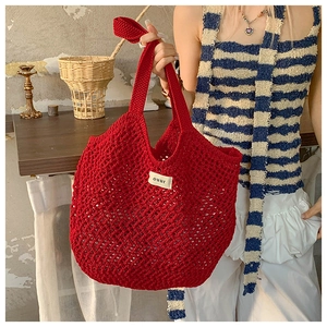 Détail du sac fourre-tout au crochet rouge avec étiquette Ouur et maille artisanale