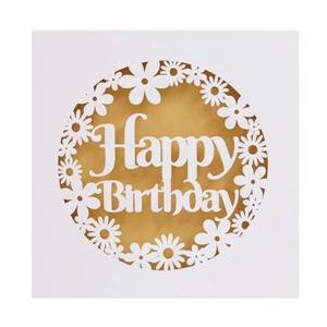 Macro view of laser-cut daisy patterns and Happy Birthday text on paper card