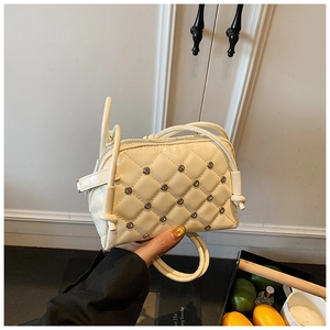 Detail shot of beige quilted crossbody bag with sparkling rhinestones and zip closure