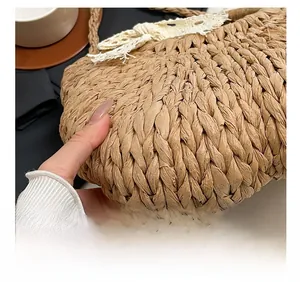 Détail du tissage en paille croisée et du nœud en dentelle blanche du sac de plage