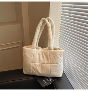 Vue détaillée du sac cabas en velours matelassé crème avec des anses souples rembourrées
