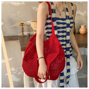 Gros plan d'un grand sac cabas rouge en maille crochetée avec larges bretelles