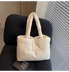 Vue détaillée du grand sac cabas matelassé beige sur une chaise au style moderne