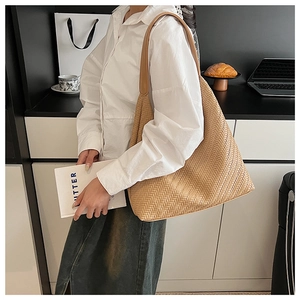 Close-up detail of light brown woven texture on large capacity tote bag with wide strap