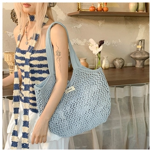 Gros plan d'un sac cabas en maille bleu clair avec une étiquette de marque blanche