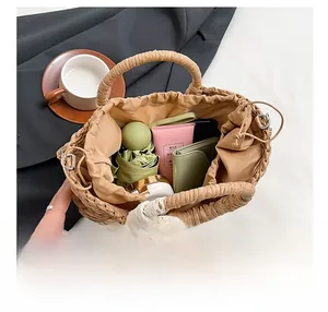 Détail du sac en paille demi-lune spacieux avec doublure à cordon et nœud
