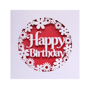 Detail of laser-cut Happy Birthday card with elegant white daisy patterns on red paper