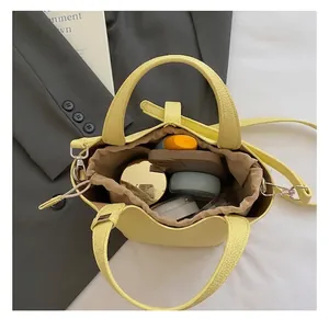 Vista interior del bolso tipo cubo amarillo con textura de grano y espacio amplio