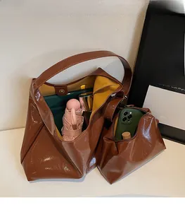 Detailed view of the spacious brown leather tote bag interior with yellow lining and pouch