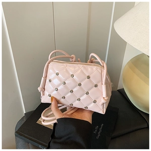 Detail of pink quilted mini crossbody bag with diamond studs and leather strap