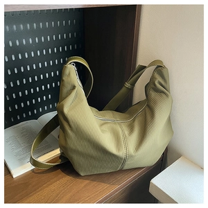 Detail of avocado green corduroy hobo bag texture with adjustable leather strap and zipper