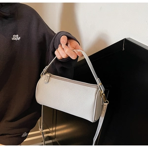 Detailed close-up of silver-gray cylindrical crossbody bag with lychee grain leather texture