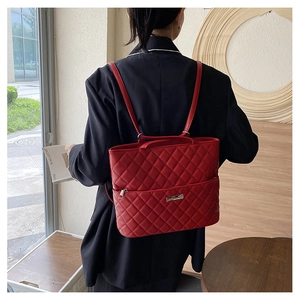 Detail of red quilted leather backpack with rhombus pattern on female model's back