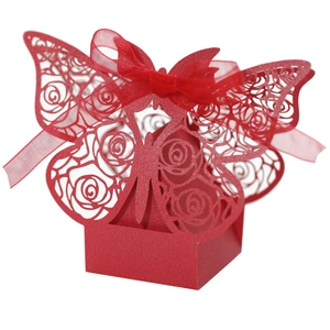 Detail of red laser-cut butterfly wedding candy box with elegant silk ribbon bow