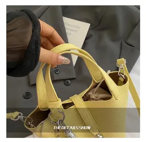 Detalle del bolso tipo cubo de cuero amarillo con forro interior de cordón