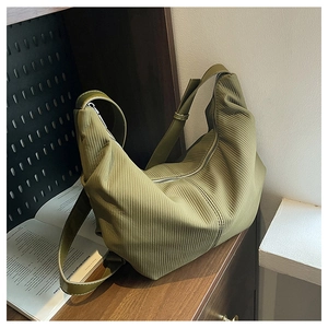 Macro detail of avocado green pleated texture and zipper on the large crossbody bag