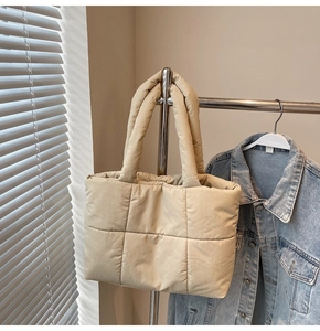 Vue détaillée du sac cabas matelassé beige montrant le tissu lisse et le rembourrage doux