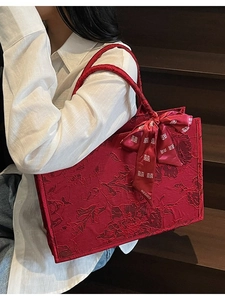 Red bridal tote bag with floral jacquard patterns and a decorative bow ribbon