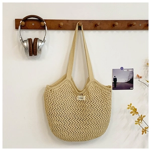 Gros plan détaillé d'un sac cabas en crochet fait main suspendu au crochet mural