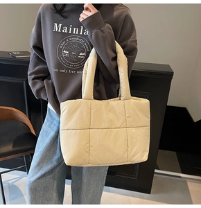 Gros plan du sac fourre-tout matelassé beige avec grand rembourrage et deux anses