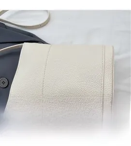 Dettaglio della borsa a tracolla avorio in pelle martellata con cuciture verticali eleganti