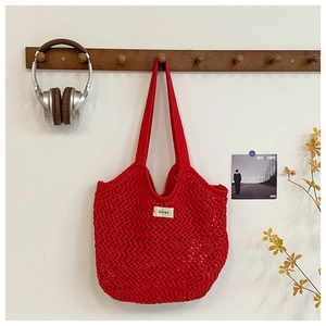 Détail d'un sac cabas en maille tissée rouge en corde de coton pour les vacances d'été
