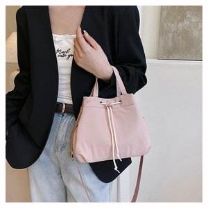 Close-up of pink nylon bucket bag featuring drawstring closure and silver metal eyelets