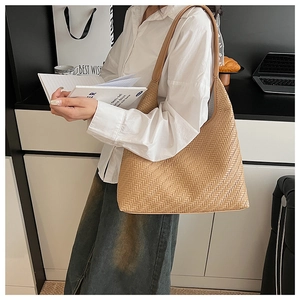 Close-up of beige woven shoulder bag showing large capacity and artisanal texture