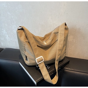 Macro detail of khaki wrinkled nylon fabric texture and wide shoulder strap on messenger bag