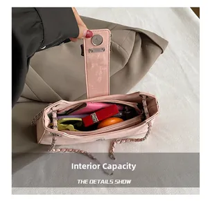 Intérieur du sac bandoulière en daim rose montrant des compartiments pour accessoires