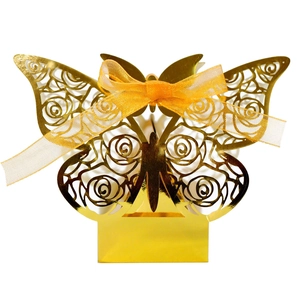 Detail of golden laser-cut butterfly candy box with rose pattern and silk ribbon