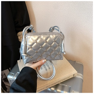 Close-up of silver quilted crossbody bag featuring sparkling rhinestones on diamond stitching