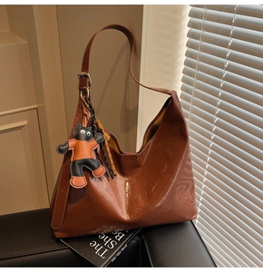 Brown oil wax leather hobo tote bag featuring a cute cat charm and golden buckle detail