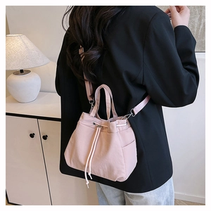 Pink nylon drawstring bucket bag shown from behind, featuring versatile shoulder straps