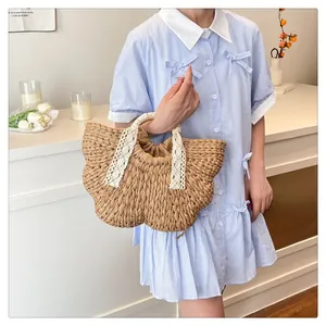 Gros plan d'un sac en paille tressée avec bordure en dentelle blanche et doublure interne