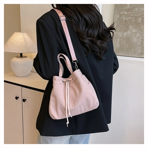 Detail view of pink nylon bucket bag with drawstring closure and adjustable strap